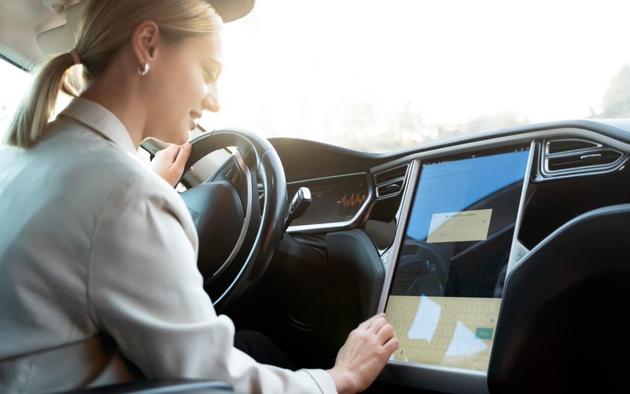 mulher em carro com condução autonóma