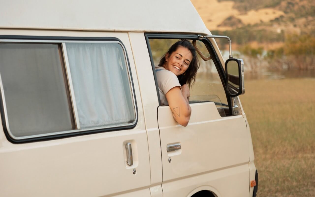 rapariga sorridente dentro depois de transformar carrinha em autocaravana