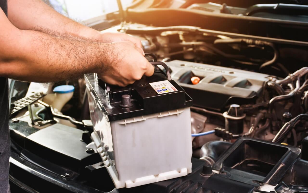 mecânico a trocar uma bateria de um carro